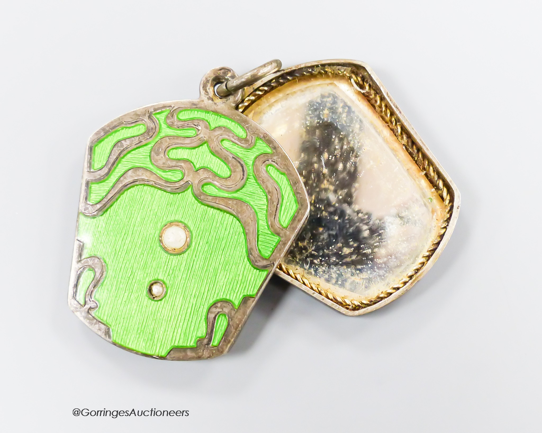 An early 20th century Austro-Hungarian white metal, green enamel and split pearl set locket, with mirrored interior, 32mm.